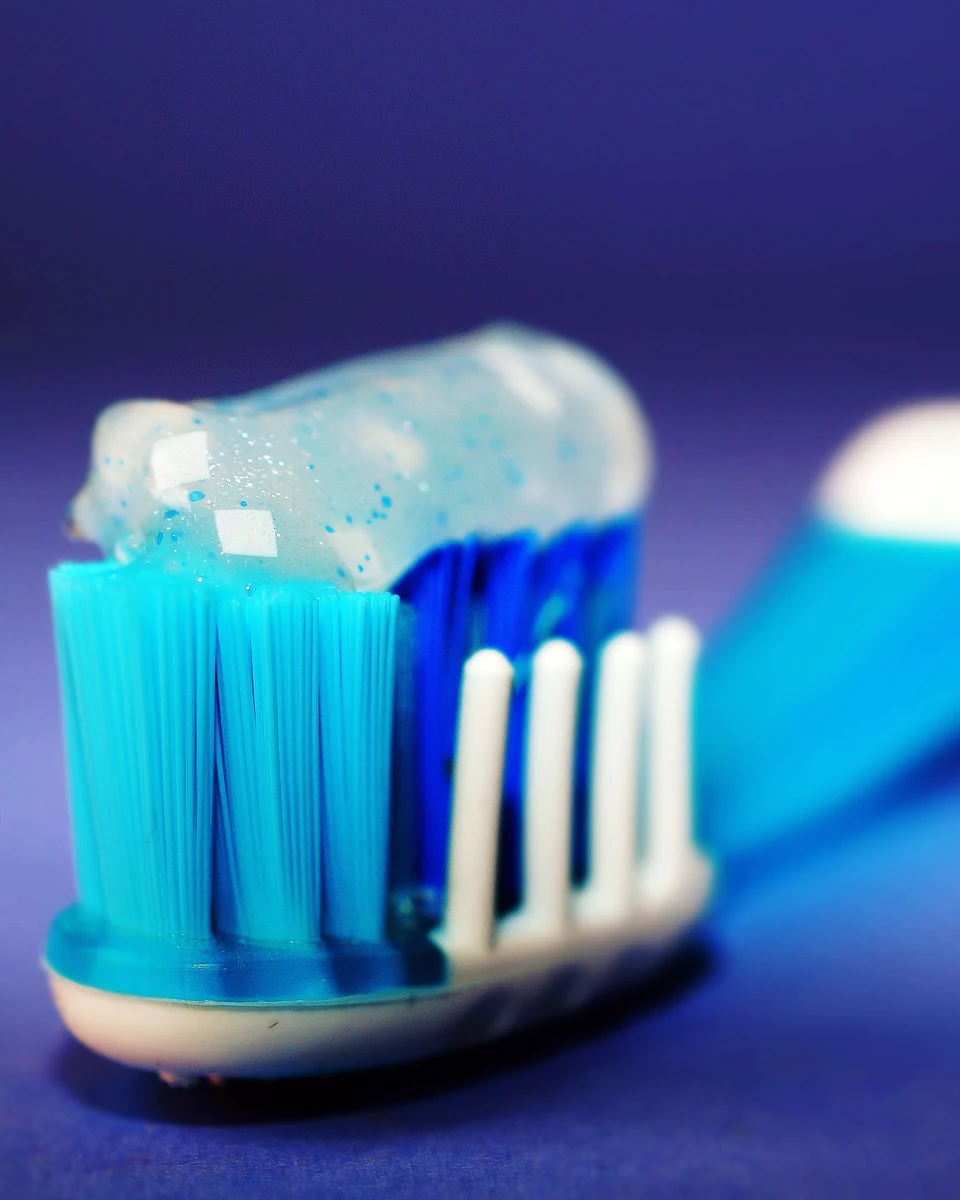 Primer plano de un cepillo de dientes con pasta dental azul