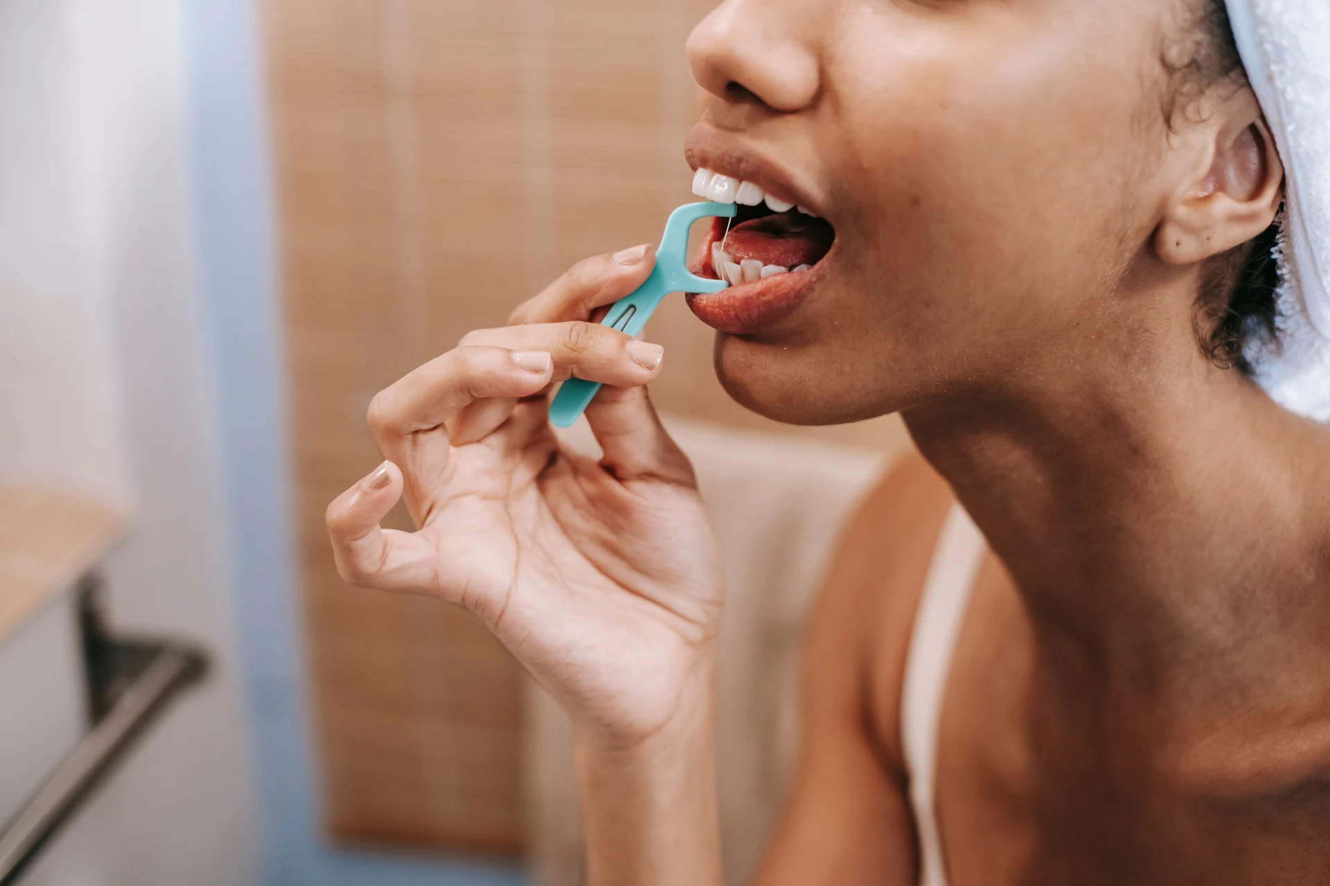 Persona utilizando un portahilo dental para limpiar entre los dientes