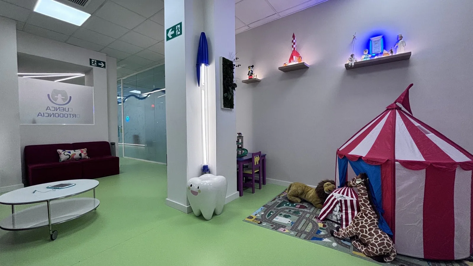 Sala de espera con sofá y rincón infantil de Cuenca Ortodoncia